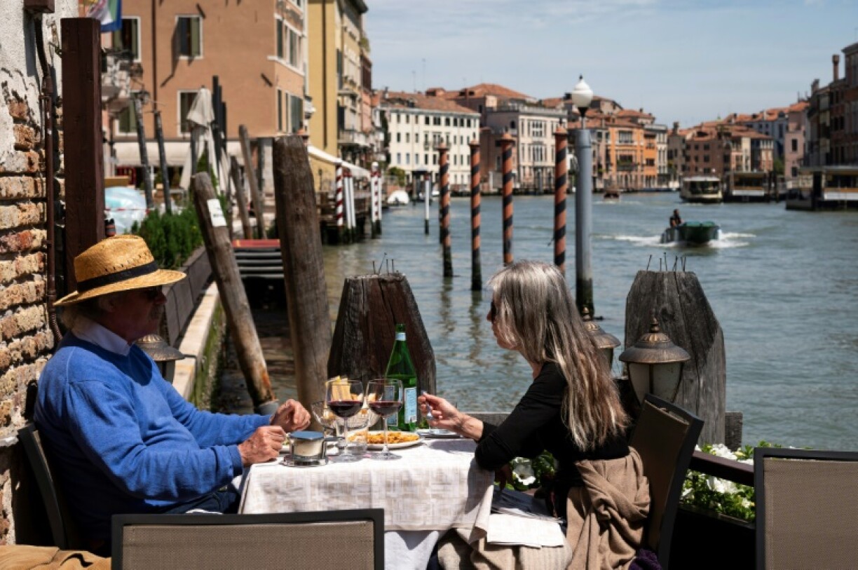 Des touristes attablés à une terrasse d'un restaurant à Venise, le 21 mai 2021