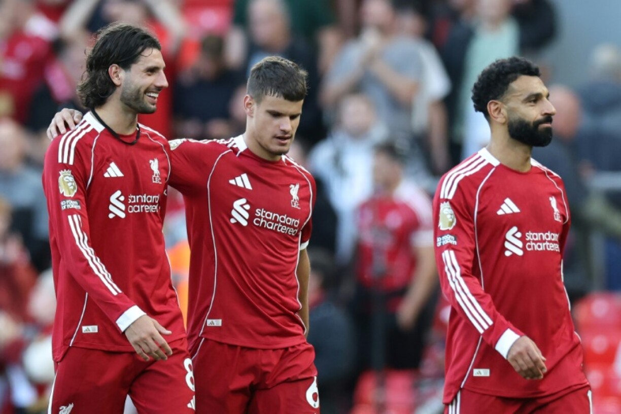 All smiles: Liverpool's scorer 8 Dominik Szoboszlai (L) walks off with defender Milos Kerkez (C) and striker Mohamed Salah after beating Arsenal