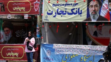 Une femme se tient sous une bannière représentant le guide suprême de l'Iran, l'ayatollah Mojtaba Khamenei, dans une rue de Téhéran, le 2 mai 2026