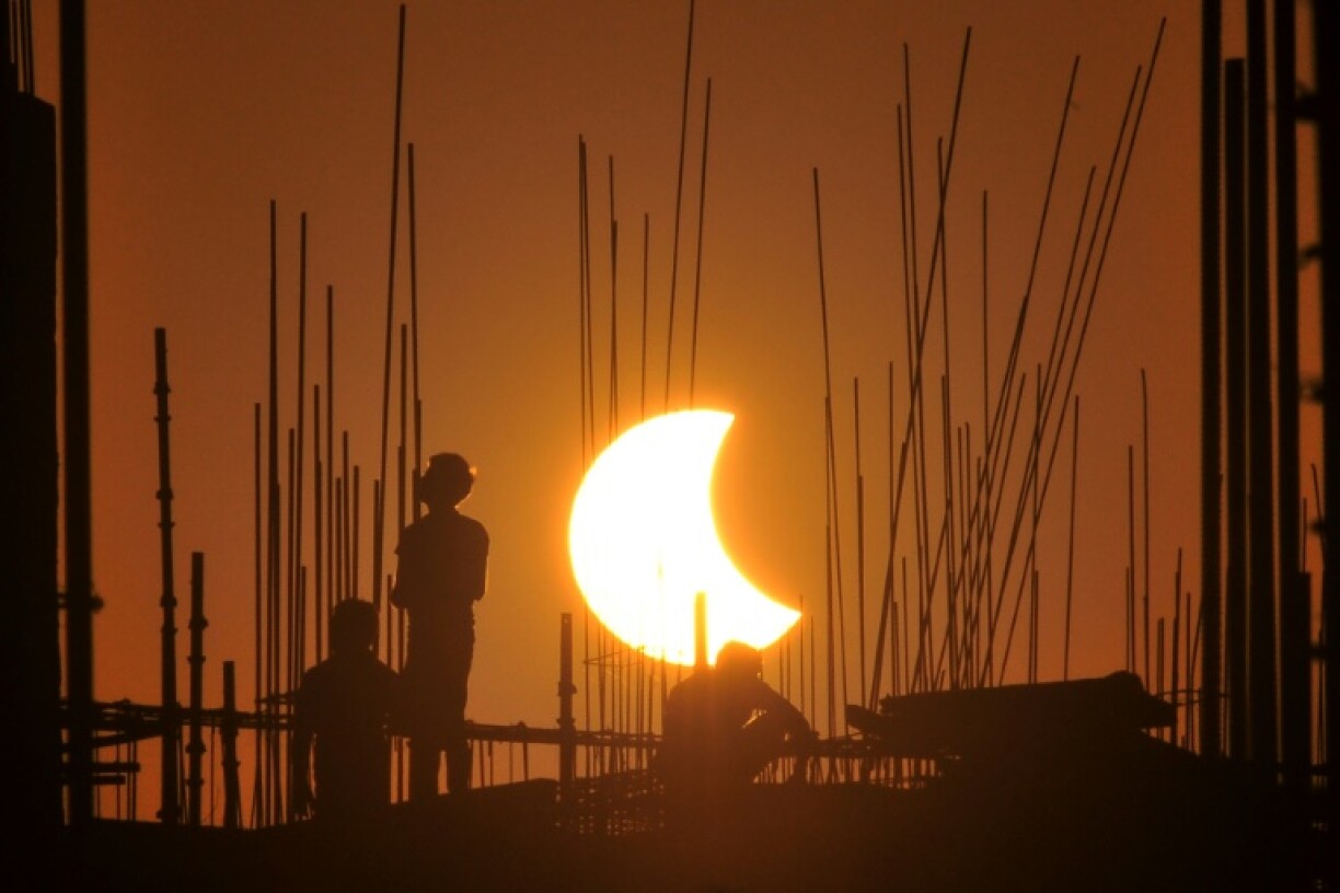 Workers at a construction site in India during 2022's partial solar eclipse