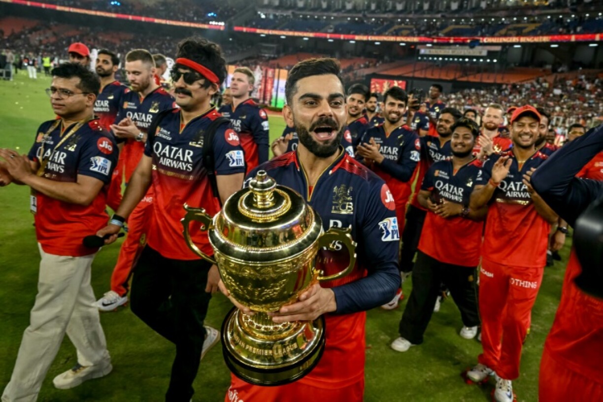 Virat Kohli (C) enjoys a lap of honour with his Royal Challengers Bengaluru teammates after they beat Punjab Kings in Ahmedabad to win their first ever IPL