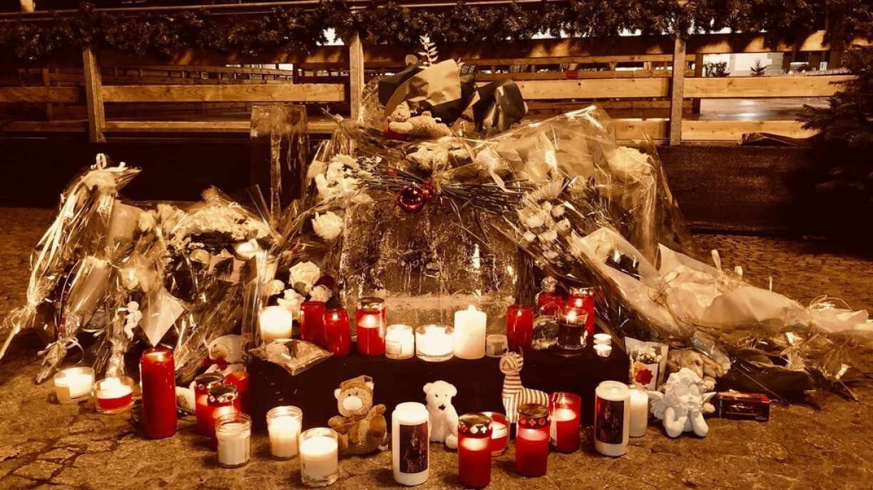 Candles, flowers, and teddy bears laid in tribute to the young victim at the scene of the tragedy.