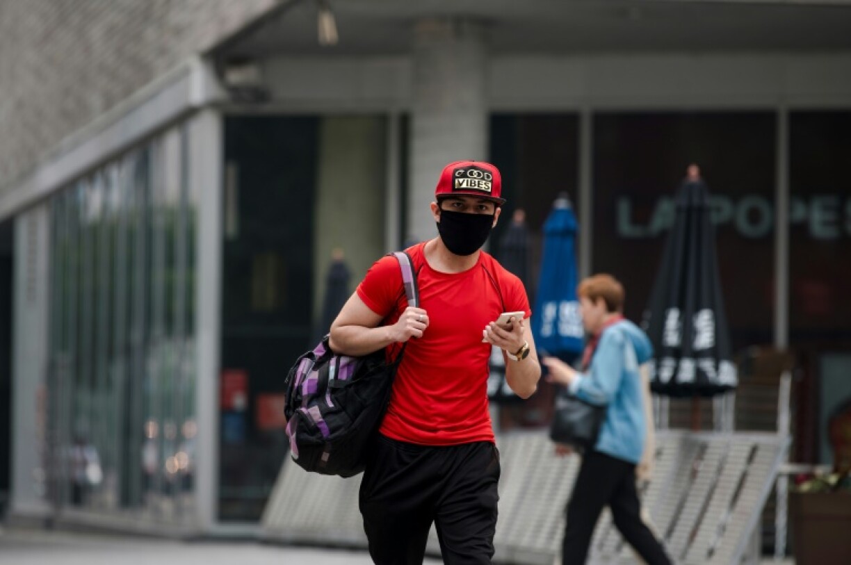 Un passant porte un masque pour se protéger de la fumée, le 25 juin 2023 dans une rue de Montréal