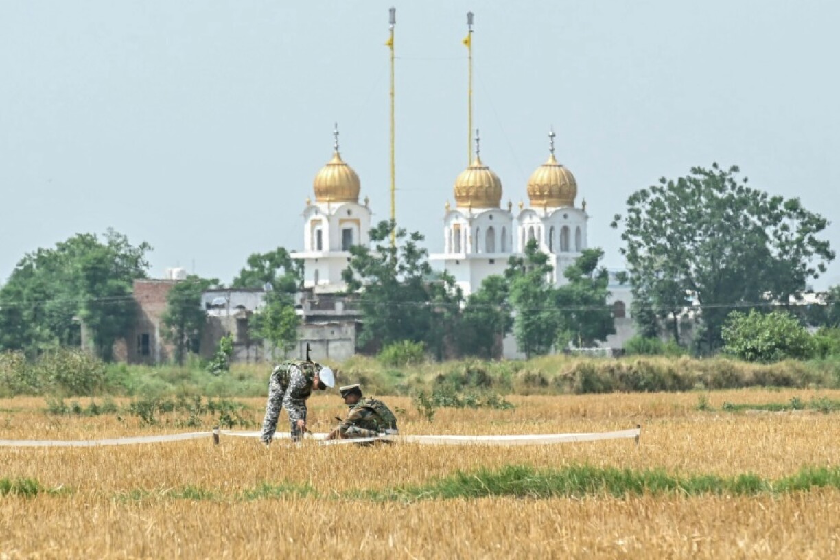 Indian soldiers inspect the debris of a missile in a field on the outskirts of Amritsar