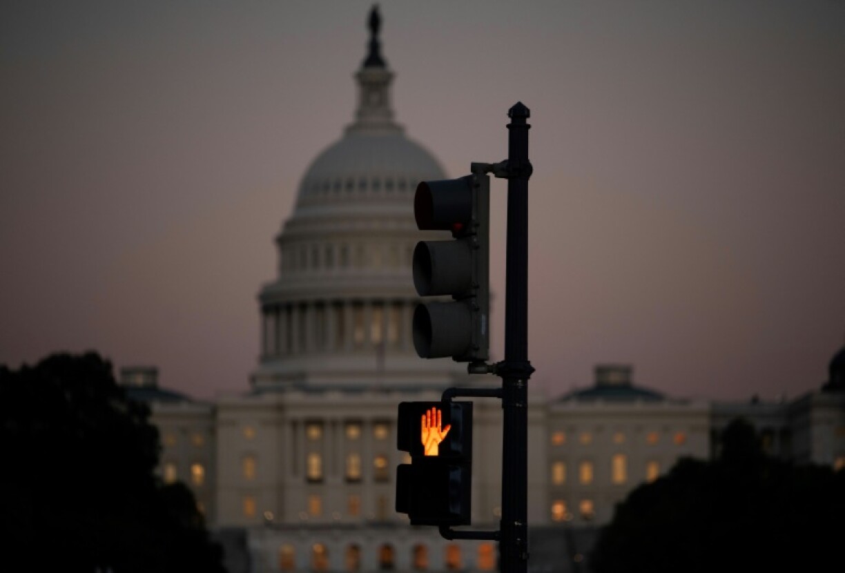 A crosswalk signal flashes, backdropped by the US Capitol, on the first day of a government shutdown that analysts warn could last for weeks