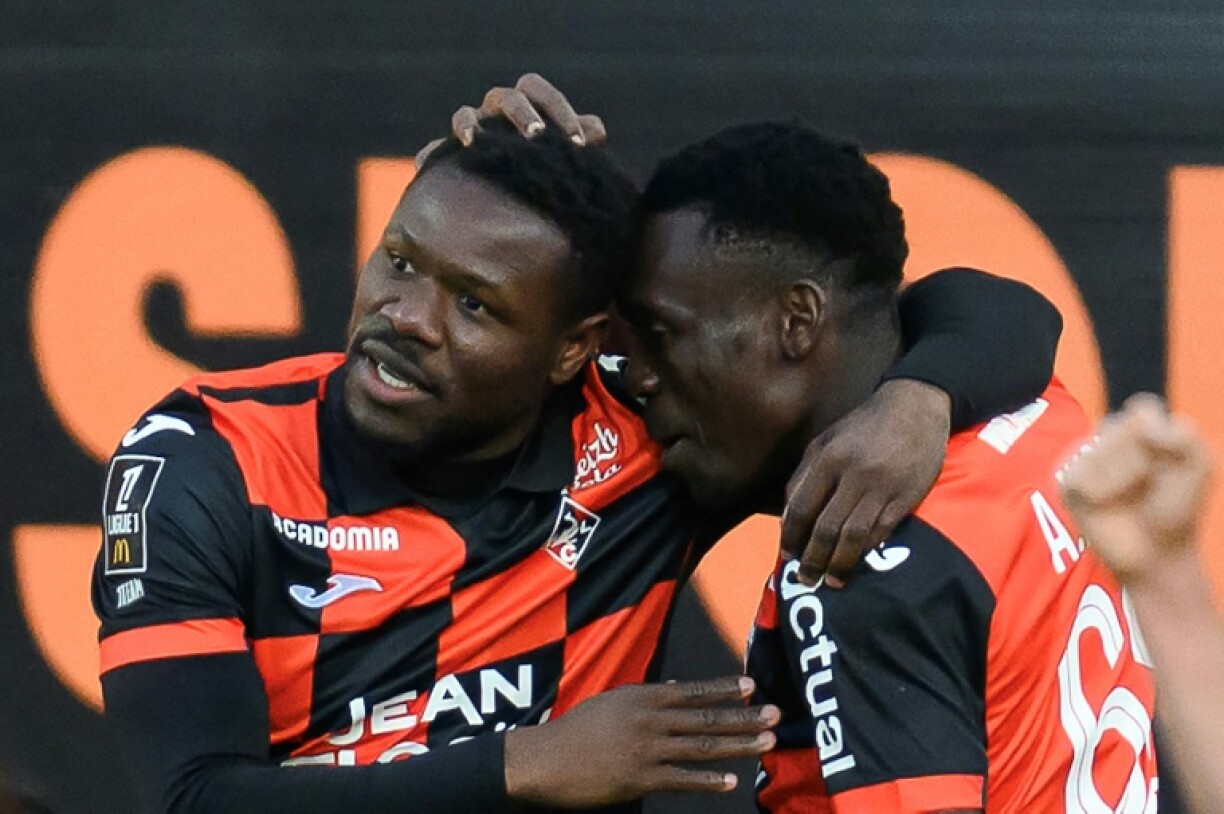 L'attaquant sénégalais de Lorient Aiyegun Tosin (G) salué par un coéquipier après avoir marqué le 2e but de son équipe, victorieuse 2-1 face à Lens samedi au stade du Moustoir
