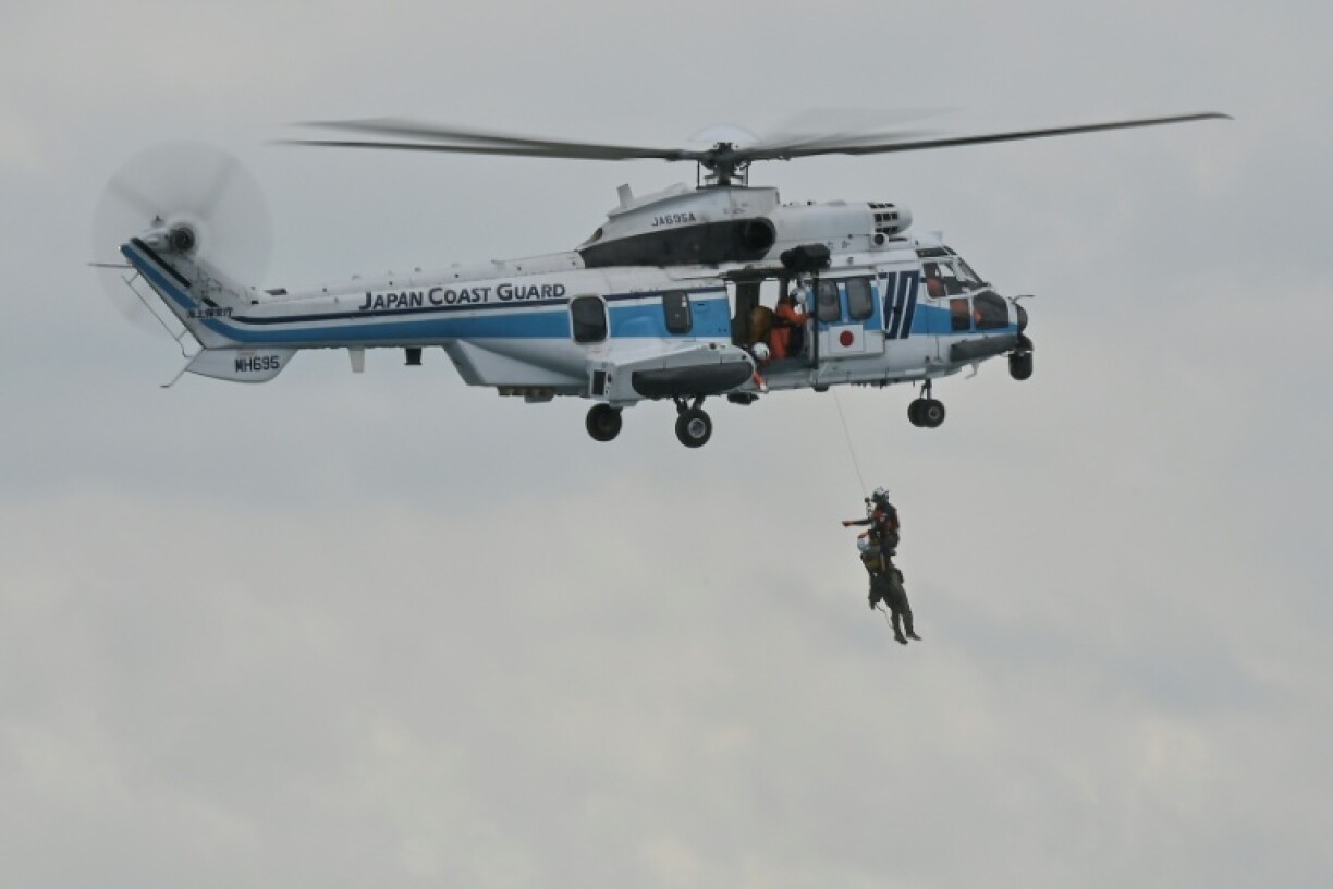 A Japan Coast Guard helicopter simulates the rescue of a man from the sea during a maritime exercise with the Philippine and US coast guards