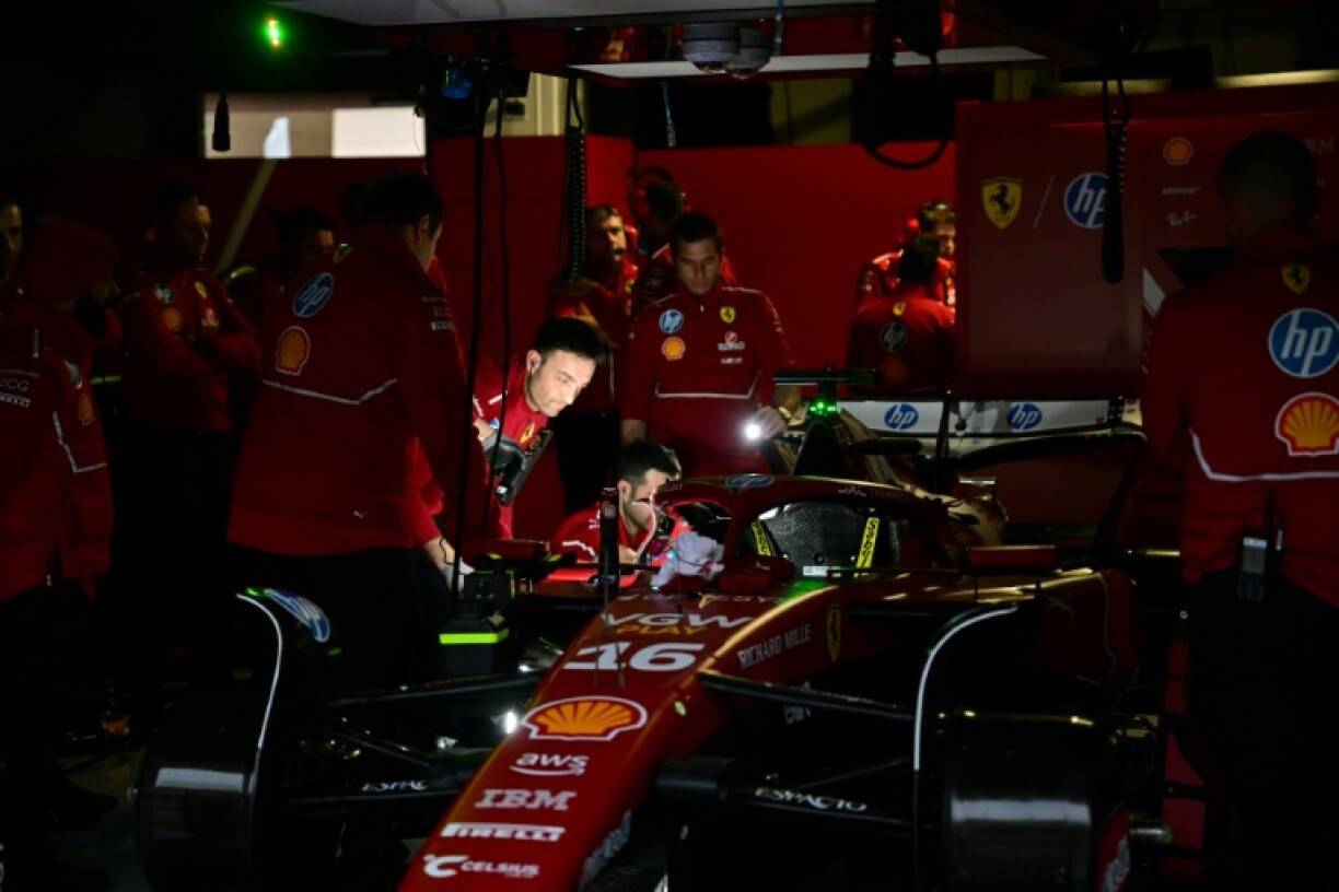 In the dark: Ferrari mechanics using flashlights during the power cut in Bahrain