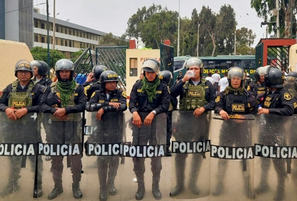 Des policiers péruviens pénètrent dans le campus de l'Université San Marcos à Lima le 21 janvier 2023