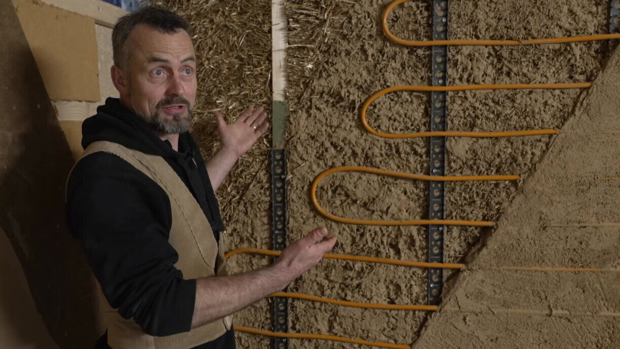 De Marc Neu virun enger Mauer mat enger Isolatioun aus Stréi a Couchen aus Leem.