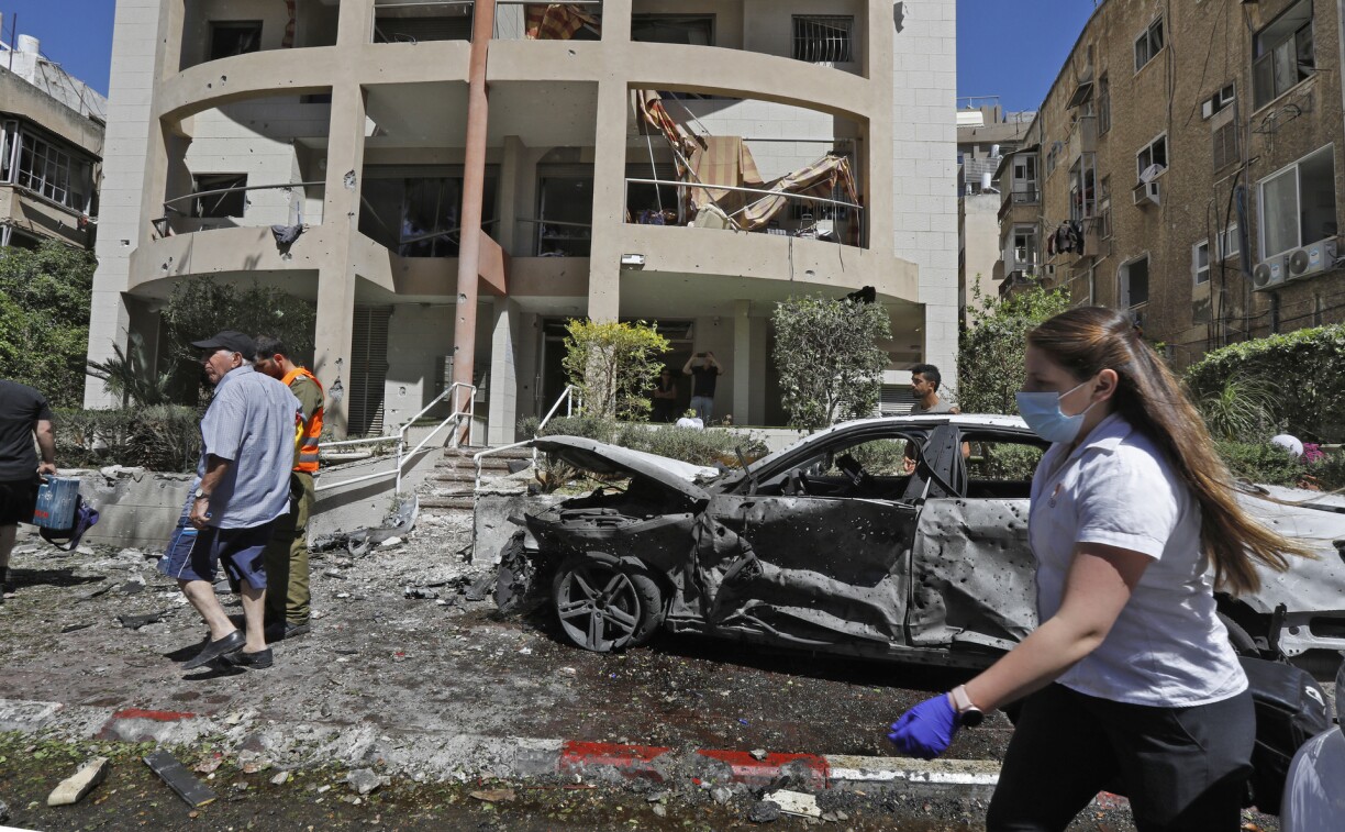 Members of Israeli security and emergency services work on a site hit by a rocket in Ramat Gan near the coastal city of Tel Aviv, on May 15, 2021, following the launching of rockets from the Gaza Strip controlled by the Palestinian Hamas movement towards