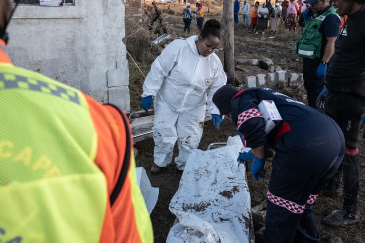 Forensics personnel write on a body bag after finding victims of the flooding near Mthatha as the death toll hit at least 78