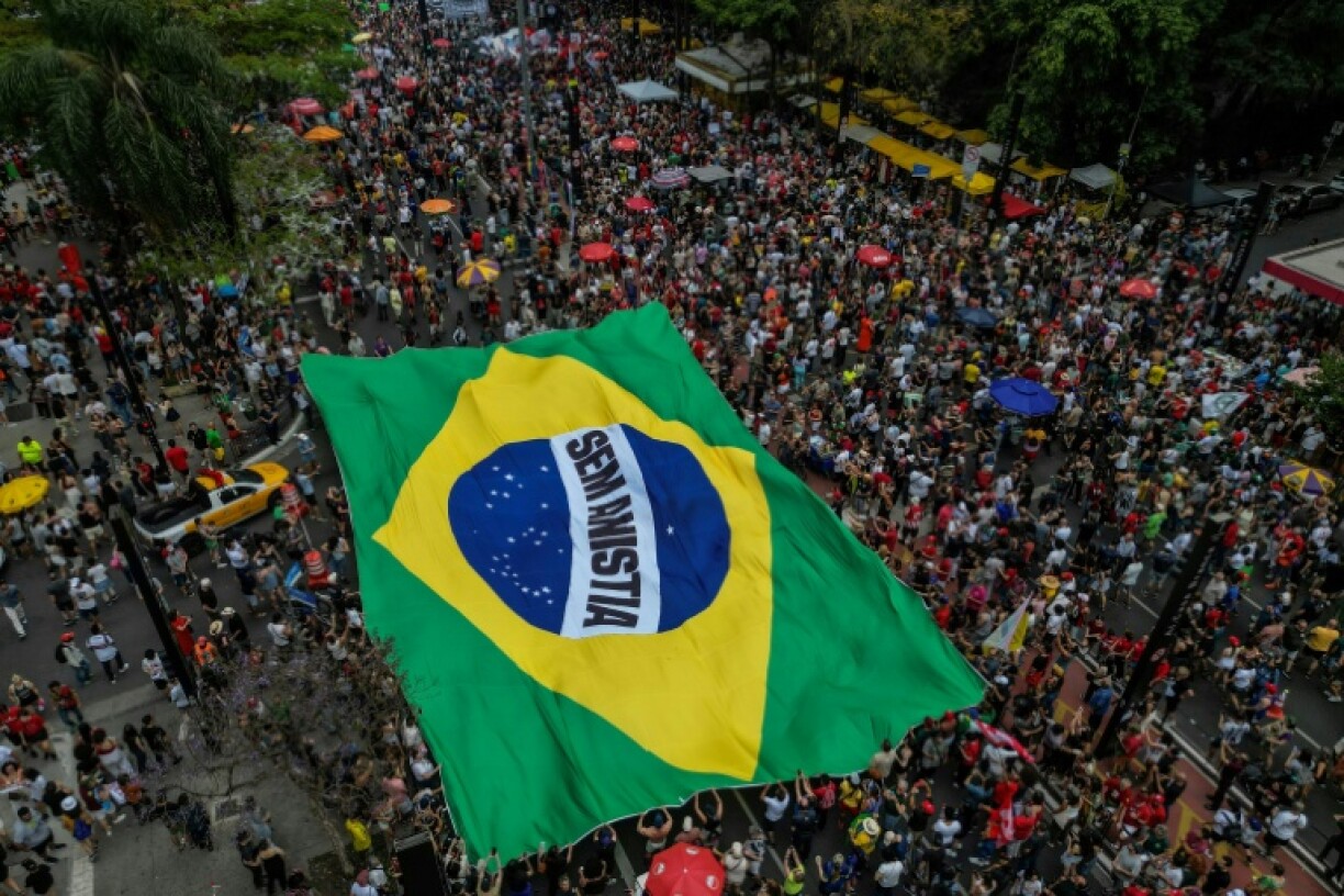 People carry a huge Brazilian flag reading