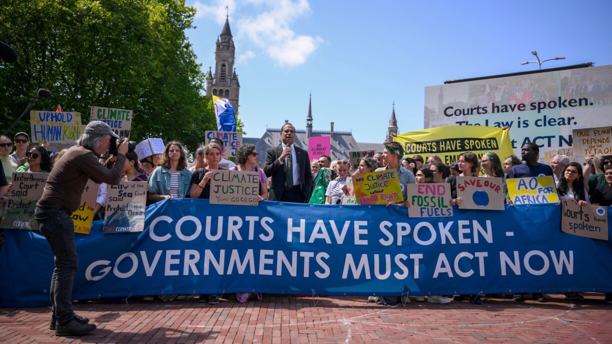 Vanuatu's Climate Change Minister Ralph Regenvanu (C) delivers a speech as he attends a demonstration ahead of the ICJ session tasked with issuing the first Advisory Opinion on States' legal obligations to address climate change, in The Hague on 23 July 2025.