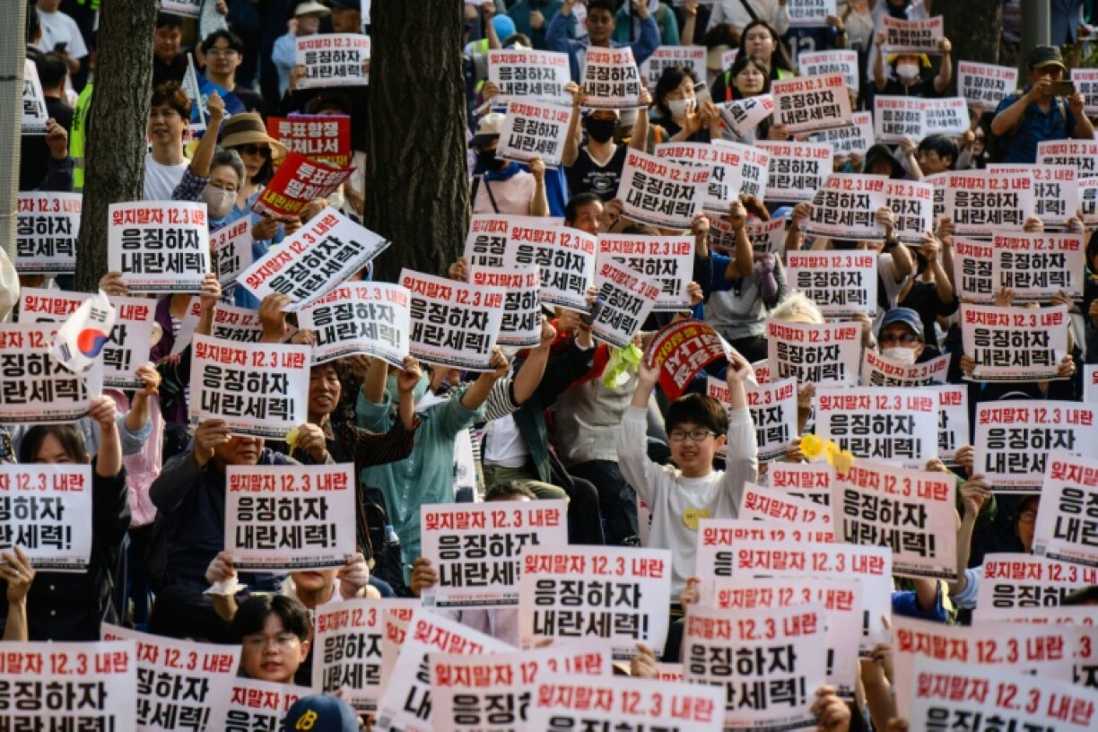 People hold placards that read