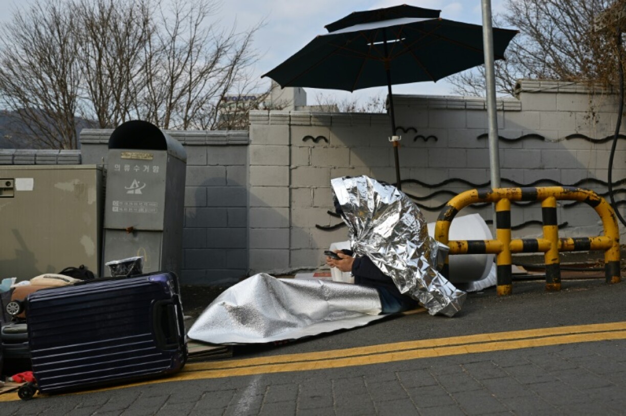 A Yoon supporter warms himself during a rally near the impeached president's residence in Seoul. Temperatures were expected to fall to -10 degrees Celsius overnight