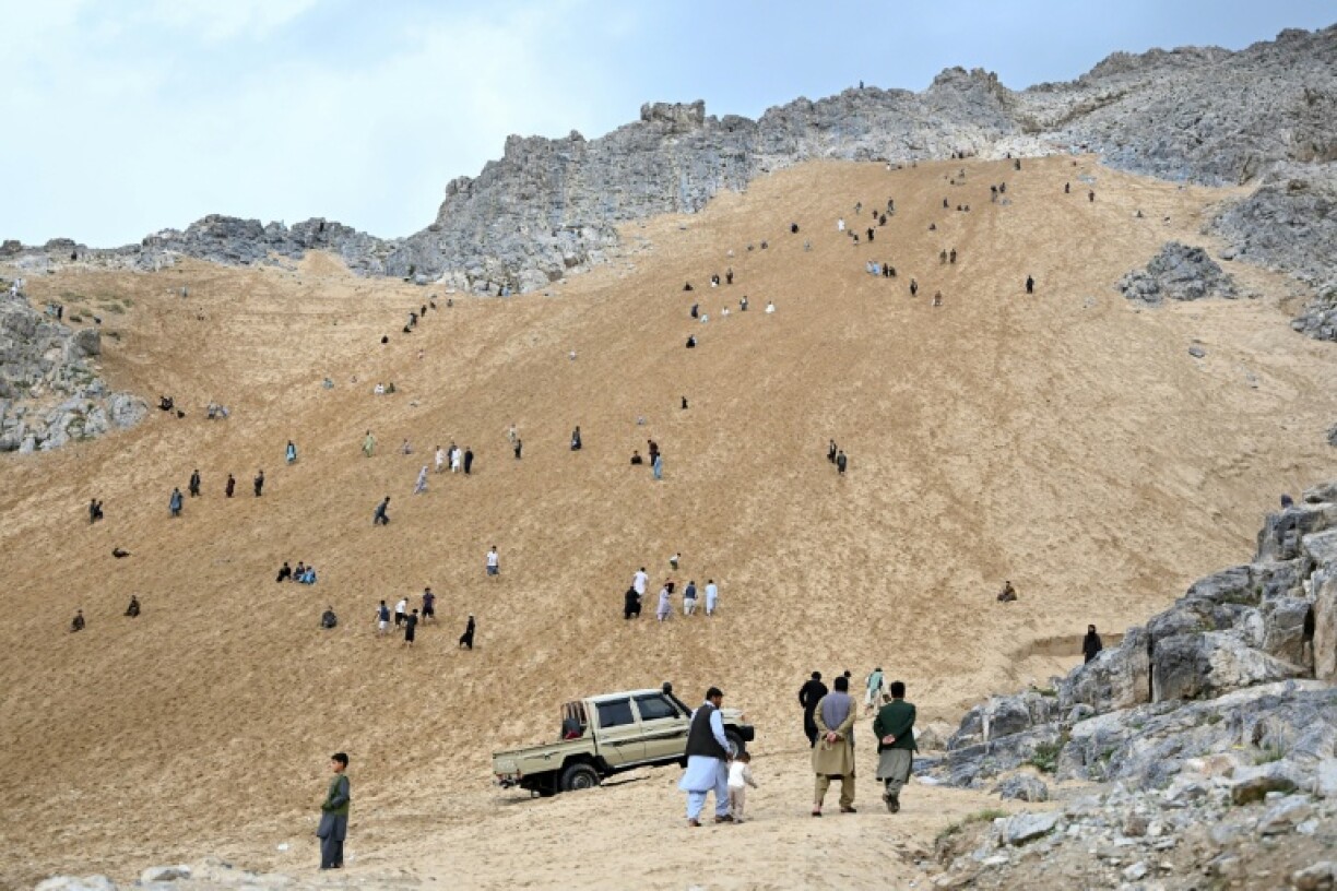 Des Afghans sur la pente sableuse de la montagne Reg-e-Rawan dans la région de Sayad, le 24 avril 2026, en Afghanistan