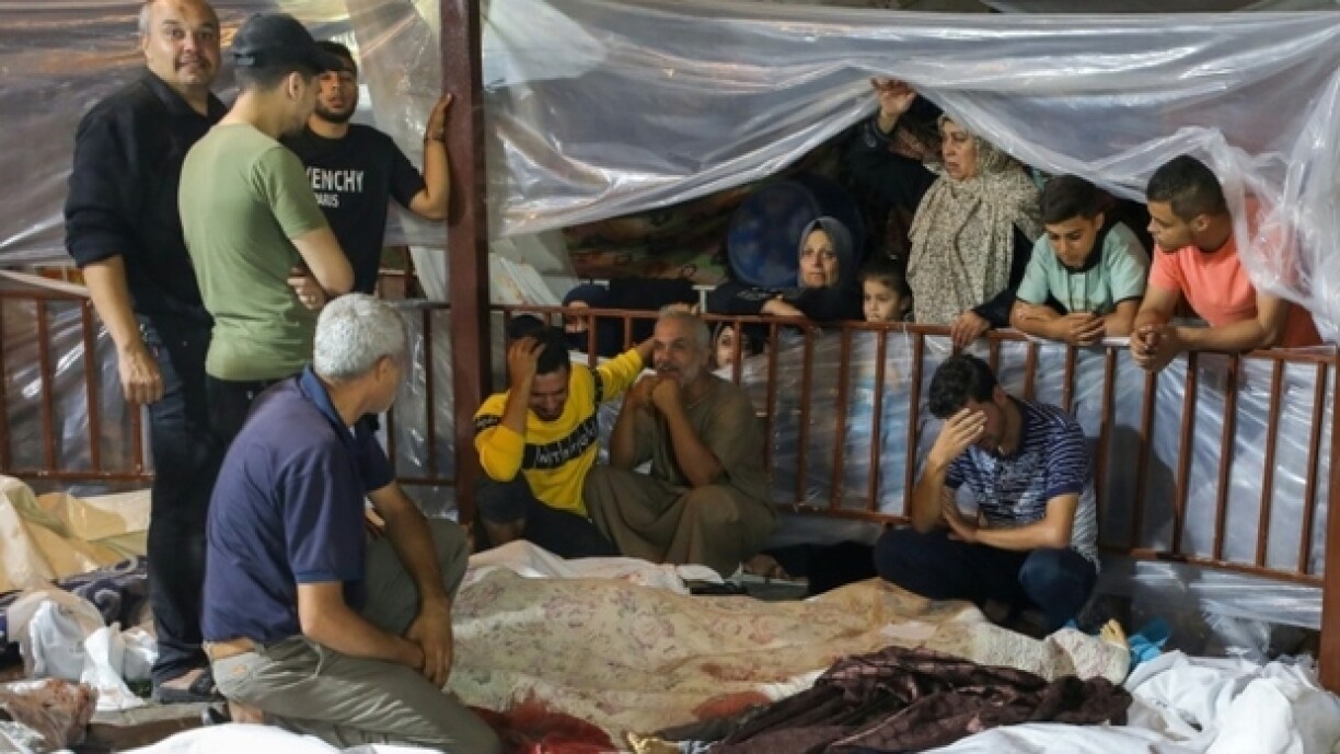 Des Palestiniens se tiennent près de corps de victimes de l'explosion de l'hôpital Ahli Arab, dans le centre de Gaza, le 17 octobre 2023