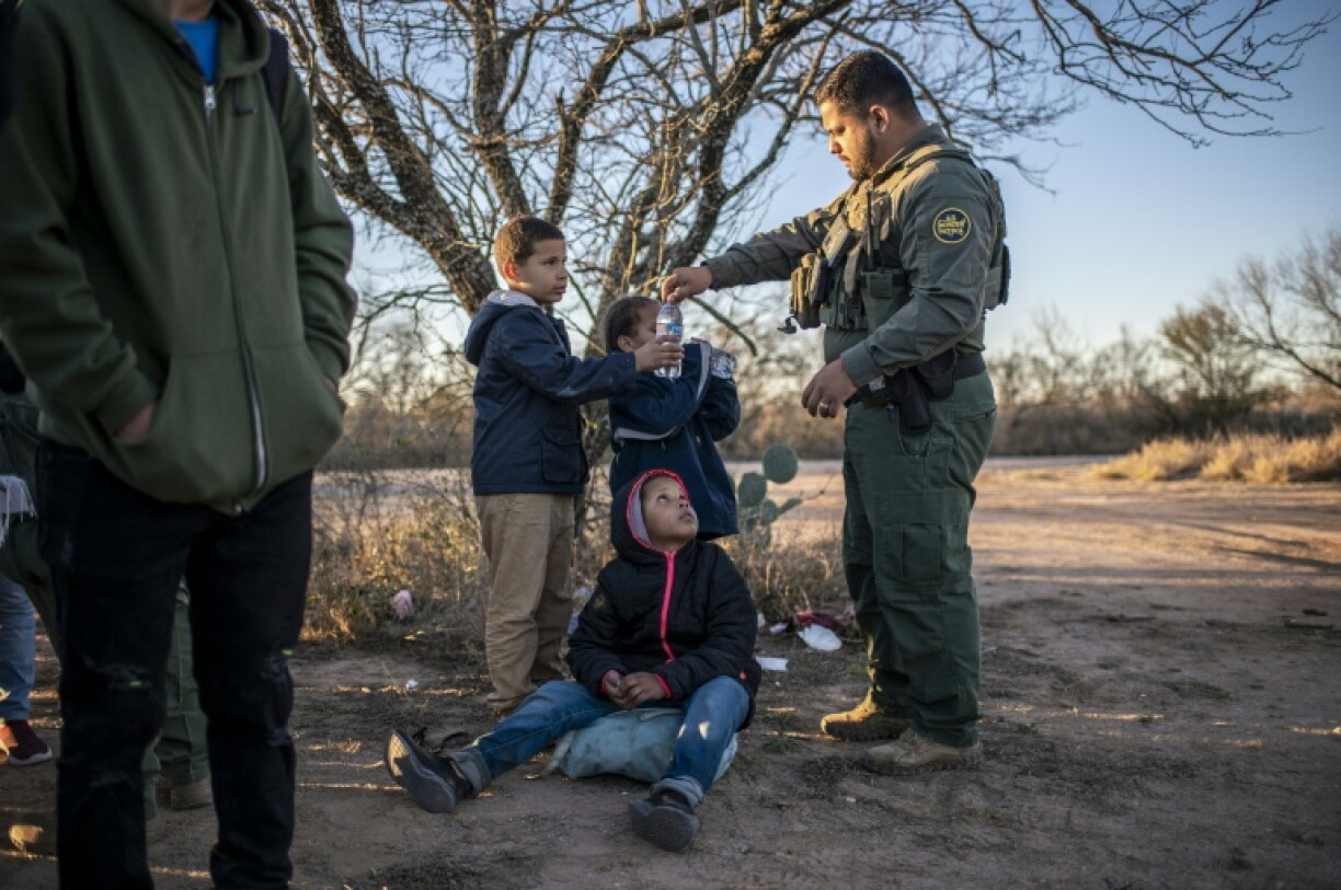 A border patrol agent gives water to unaccompanied children arrested near Eagle Pass, Texas