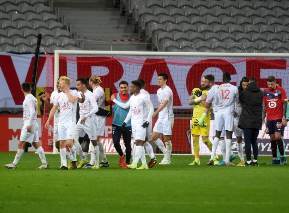 La joie des Nîmois après leur victoire, 2-1 face à Lille, lors de leur match de L1, le 21 mars 2021 au stade Pierre Mauroy à Villeneuve d'Ascq