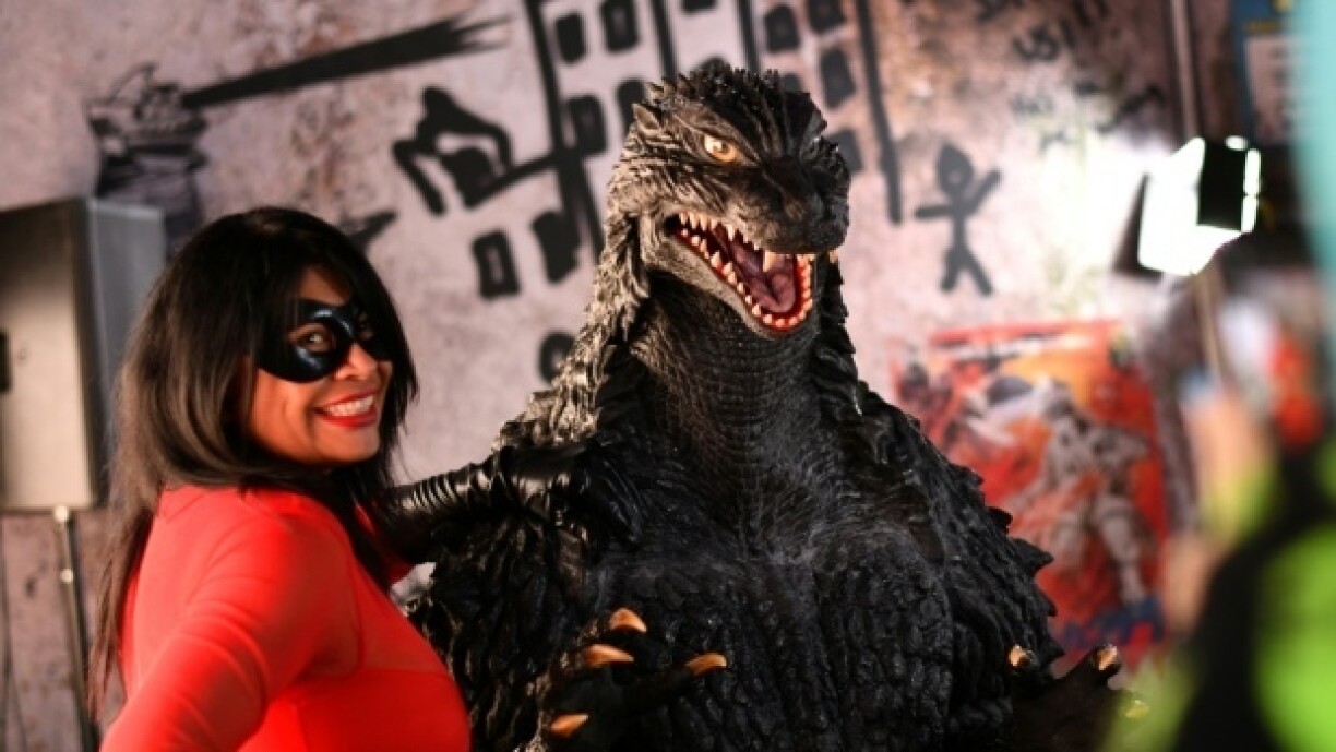 Une participante du Comic-Con pose avec une réplique de Godzilla à San Diego, en Californie, le 26 juillet 2025