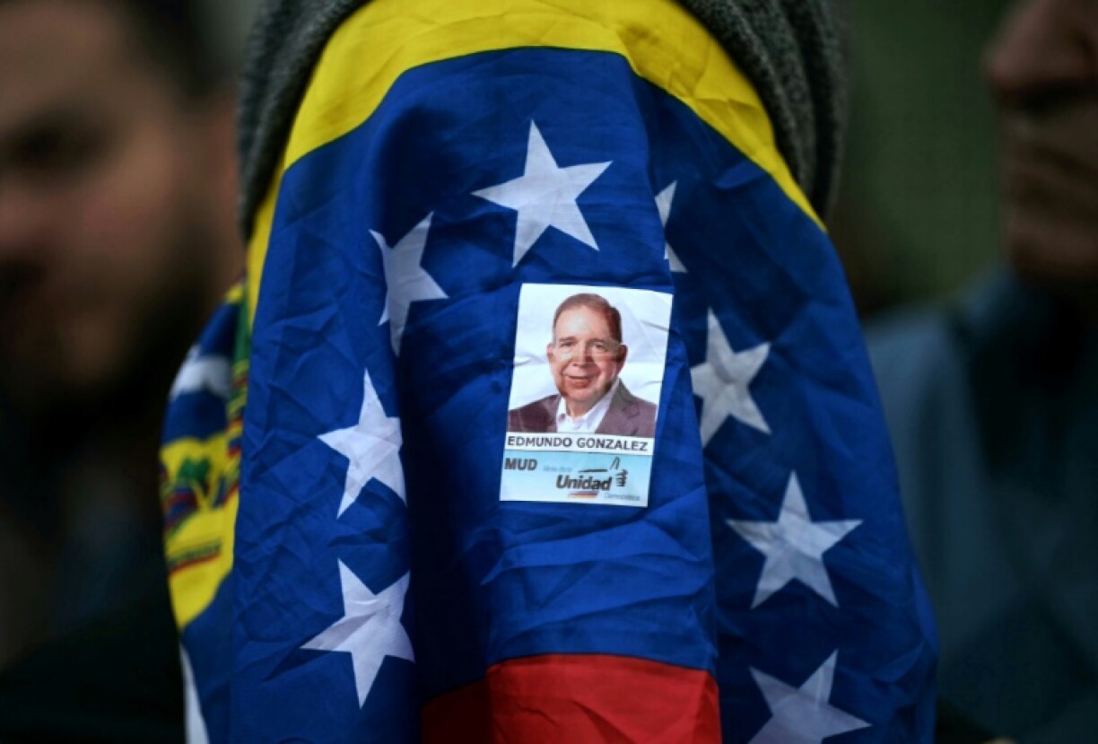 Une femme le visage couvert du drapeau du Venezuela et d'un autocollant du candidat de l'opposition Edmundo Gonzalez Urrutia lors d'une veillée pour la libération des prisonniers politiques arrêtés après la présidentielle, à Caracas, le 8 août 2024