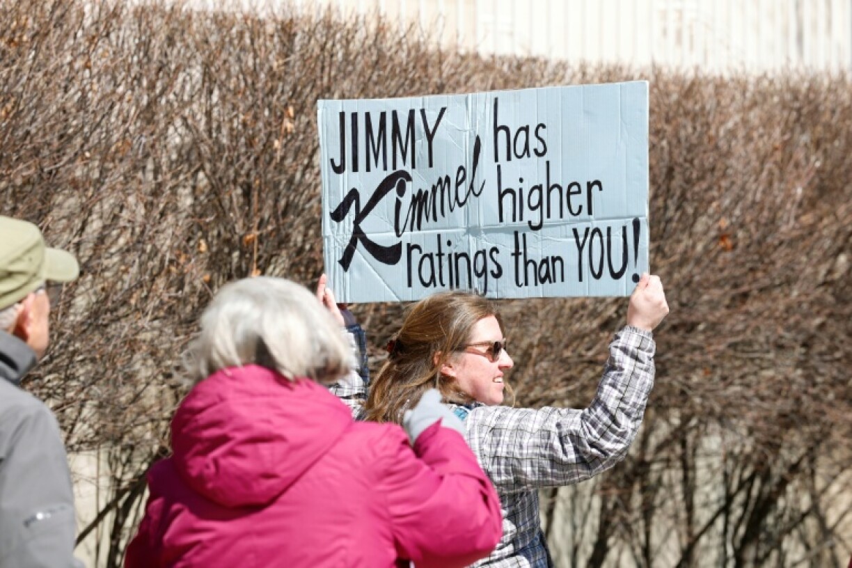 Une personne brandit une pancarte sur laquelle est écrit "Jimmy Kimmel a de meilleures audiences que toi" à Chicago lors d'une journée nationale de protestation contre le président américain Donald Trump, le 28 mars 2026