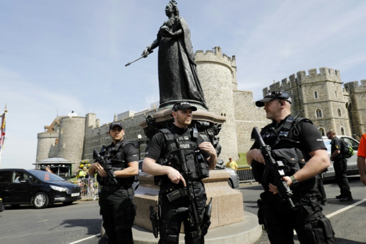Armed British police officers patrol near Windsor Castle on May 18, 2018, the day before Prince Harry's marriage to Meghan Markle