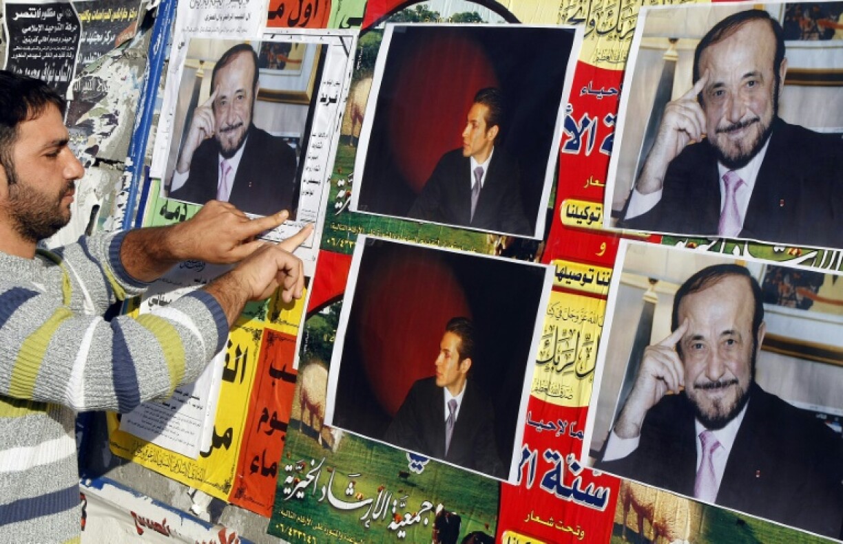Un homme colle des affiches de Rifaat al-Assad, l'oncle du président syrien, le 6 décembre 2007 à Tripoli.