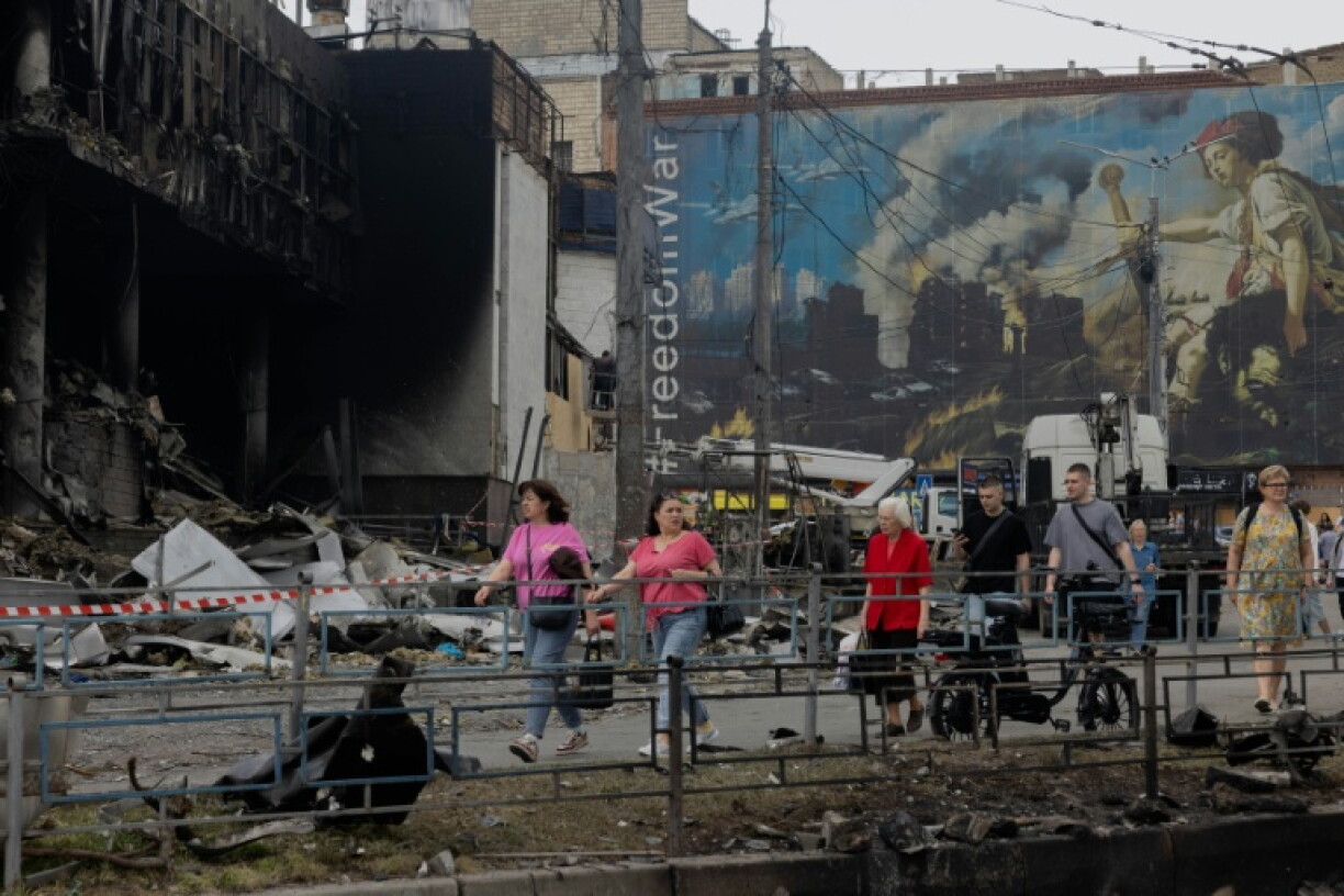Des habitants passent devant un centre commercial endommagé à la suite des frappes russes à Kiev, le 25 mai 2026