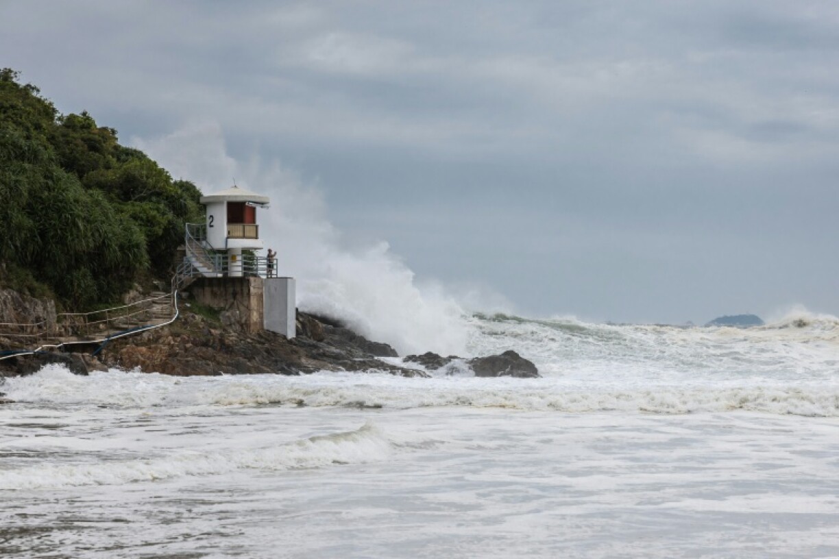 A man watches large waves break at a beach as Super Typhoon Ragasa moved towards Hong Kong
