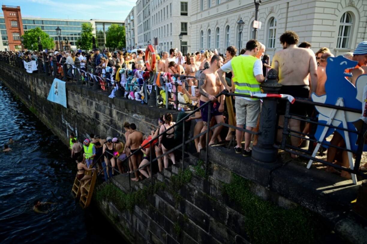 Berliners line up to take a dip in the Spree during a demonstration against the ban on swimming in the river