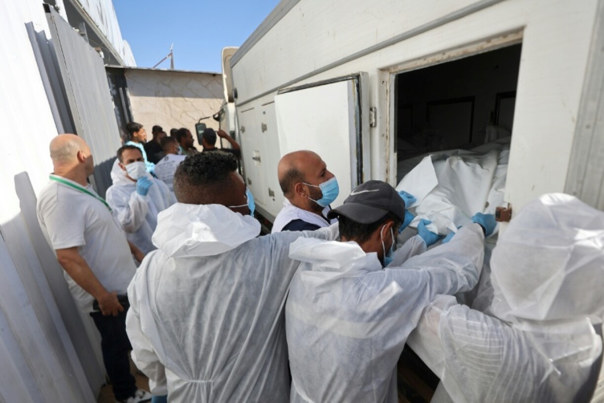 Morgue workers unload the bodies of Palestinians that had been in Israeli custody, after they were transported by Red Crescent vehicles and refrigerated trucks to Khan Yunis in the Gaza Strip