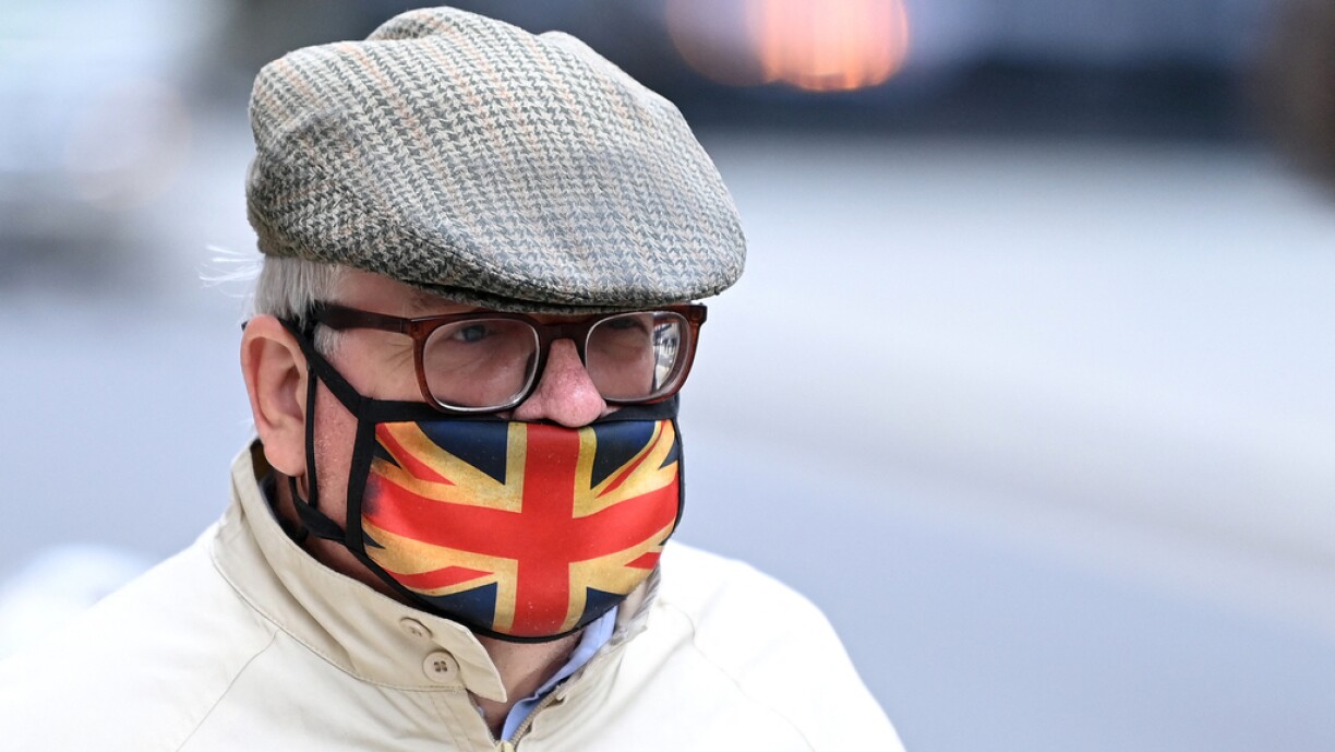 A man wears a Union flag-themed face covering, as a precation against the spread of Covid-19, as he walks along a street in London on September 30, 2021.