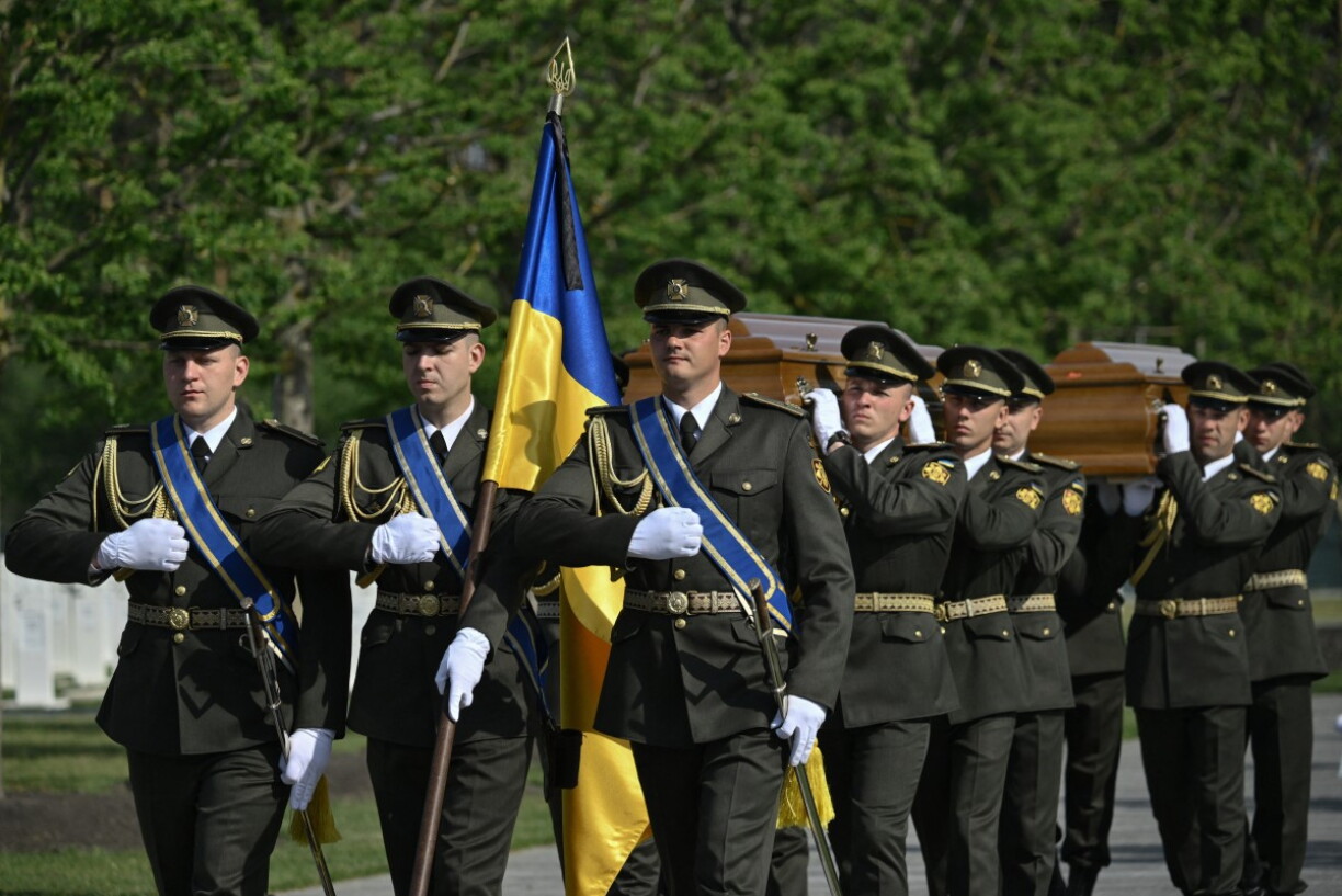 Des membres de la Garde d'honneur ukrainienne portent les cercueils d'Andriy Melnyk, décédé en 1964 et chef d'une branche de l'Organisation des nationalistes ukrainiens (OUN), et de son épouse Sofia, lors de leur cérémonie de réinhumation au cimetière militaire national près de Kyiv, le 25 mai 2026, en pleine invasion russe de l'Ukraine. Andriy Melnyk avait été inhumé au Luxembourg après son décès à Cologne, en Allemagne de l'Ouest. Son rapatriement s'inscrit dans un projet plus vaste, mené par l'État, visant à créer un panthéon dédié aux héros historiques.