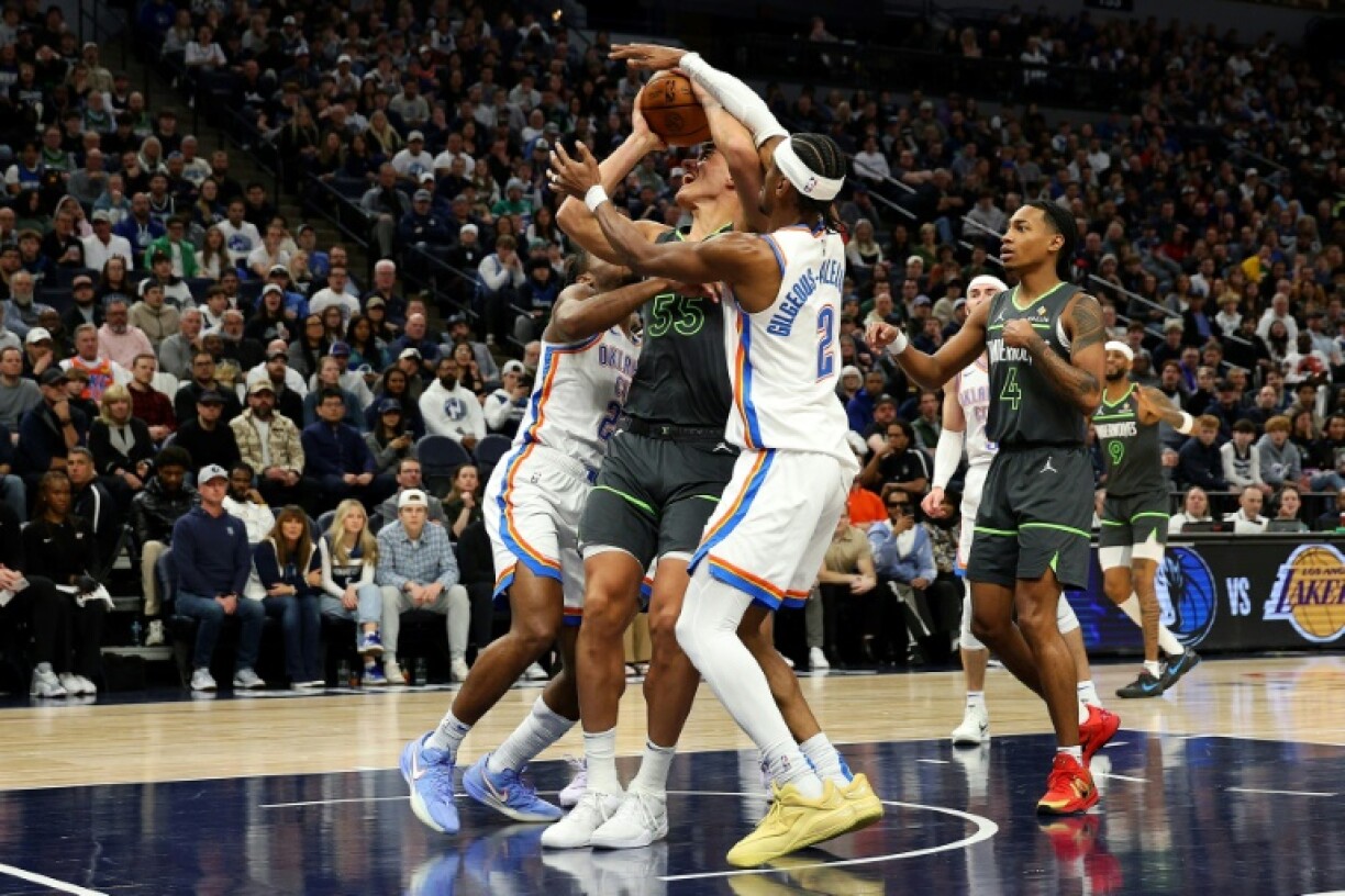 Luka Garza of the Minnesota Timberwolves draws a foul against Shai Gilgeous-Alexander of the Oklahoma City Thunder during the Thunder's NBA win over the Timberwolves