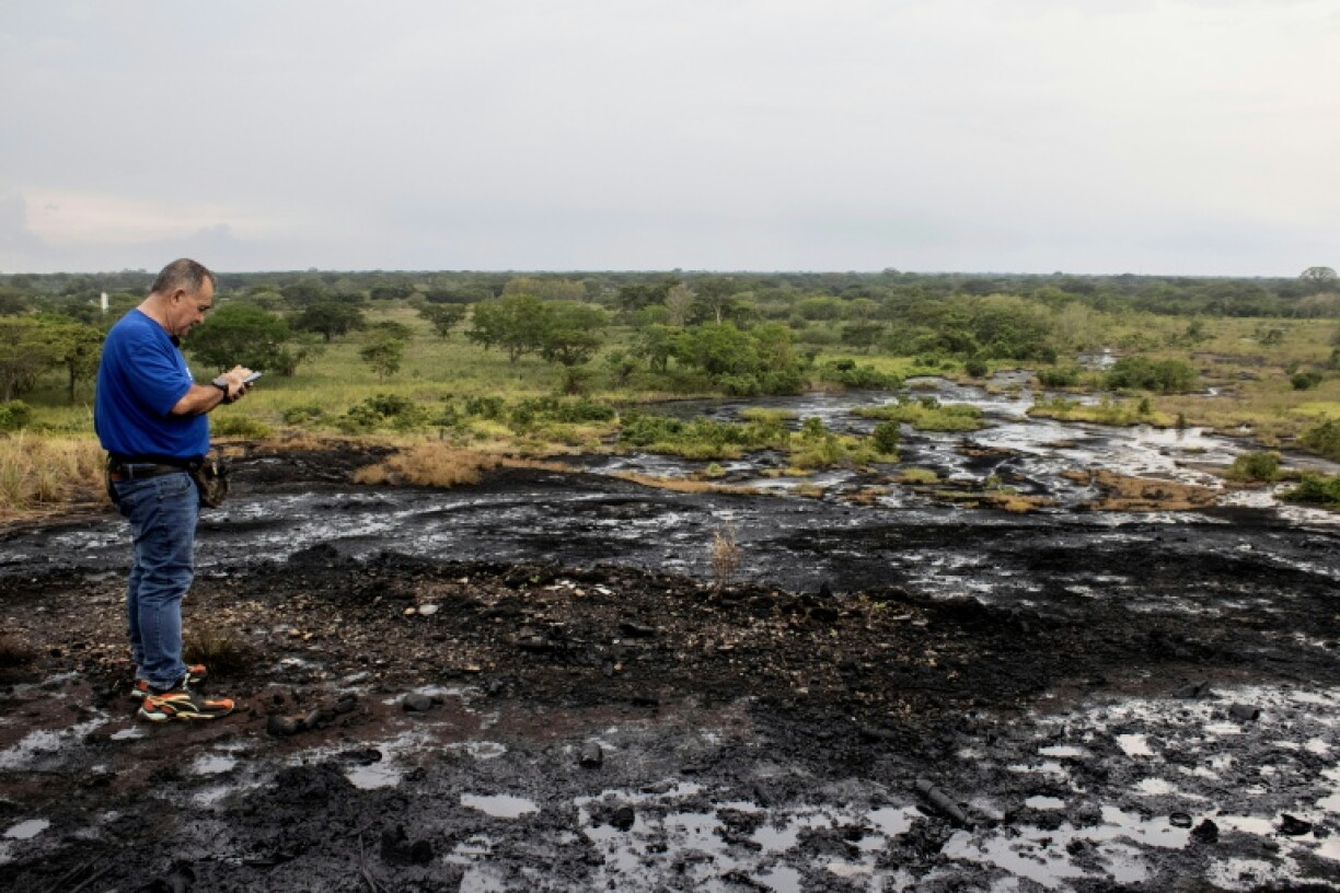 Hector Valero Balestrini walks over crude oil seeping to the surface at Cerro Miosa