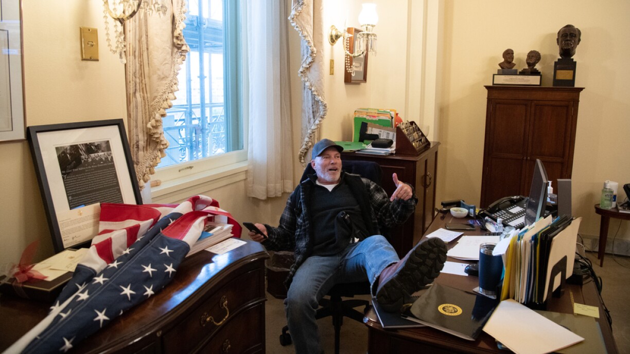 Richard Barnett, a supporter of US President Donald Trump sits inside the office of US Speaker of the House Nancy Pelosi as he protest inside the US Capitol in Washington, DC, January 6, 2021.
