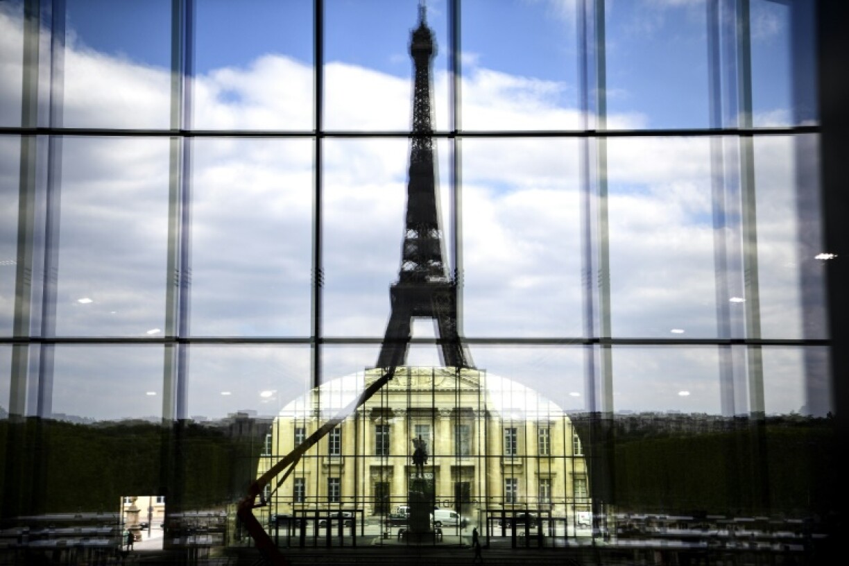 La façade de l'Ecole Militaire alignée à la Tour Eiffel se reflètent sur le Grand Palais éphémère de Jean-Michel Wilmotte, à Paris le 3 mai 2021