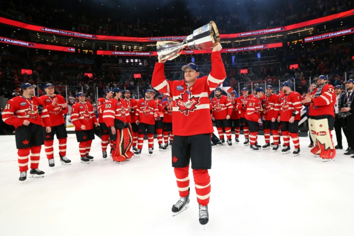 Tournament Most Valuable Player and goals leader Nathan MacKinnon of Team Canada holds the trophy aloft after beating the United States in the Four Nations Face-Off final