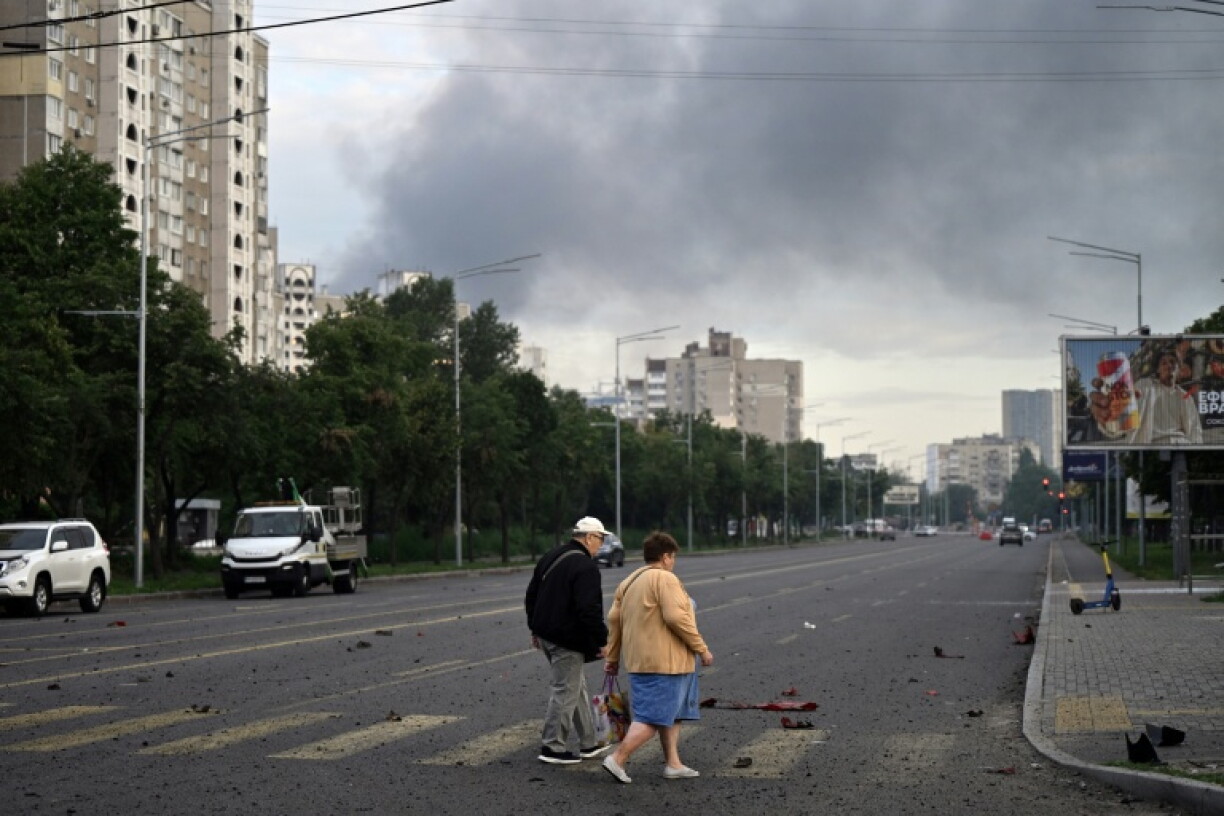 Des habitants marchent dans une rue de la capitale de l'Ukraine, Kiev, après une attaque de missiles russes, le 11 juillet 2026