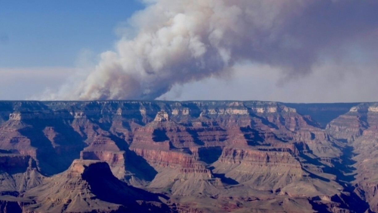 Une photo du Grand Canyon, surplombé par une colonne de fumée à cause d'un incendie, fournie par la direction du parc naturel américain le 11 juillet 2025