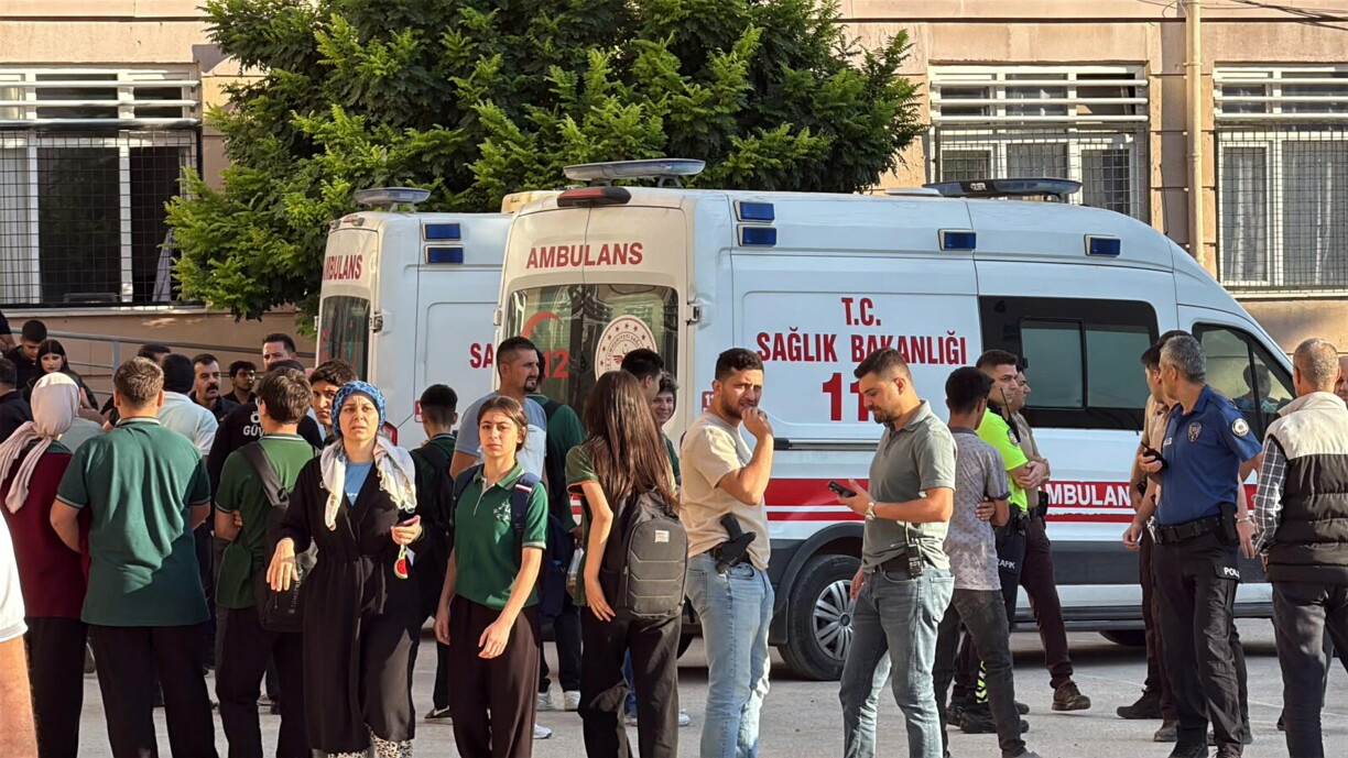 This handout photograph taken and released on 22 September 2026 by Turkish news agency DHA (Demiroren News Agency) shows ambulances and police officers waiting in front of a high school outside which a gunman opened fire wounding eight people, and was detained shortly afterwards, in Turgutlu, an area west of the resort city of Izmir.