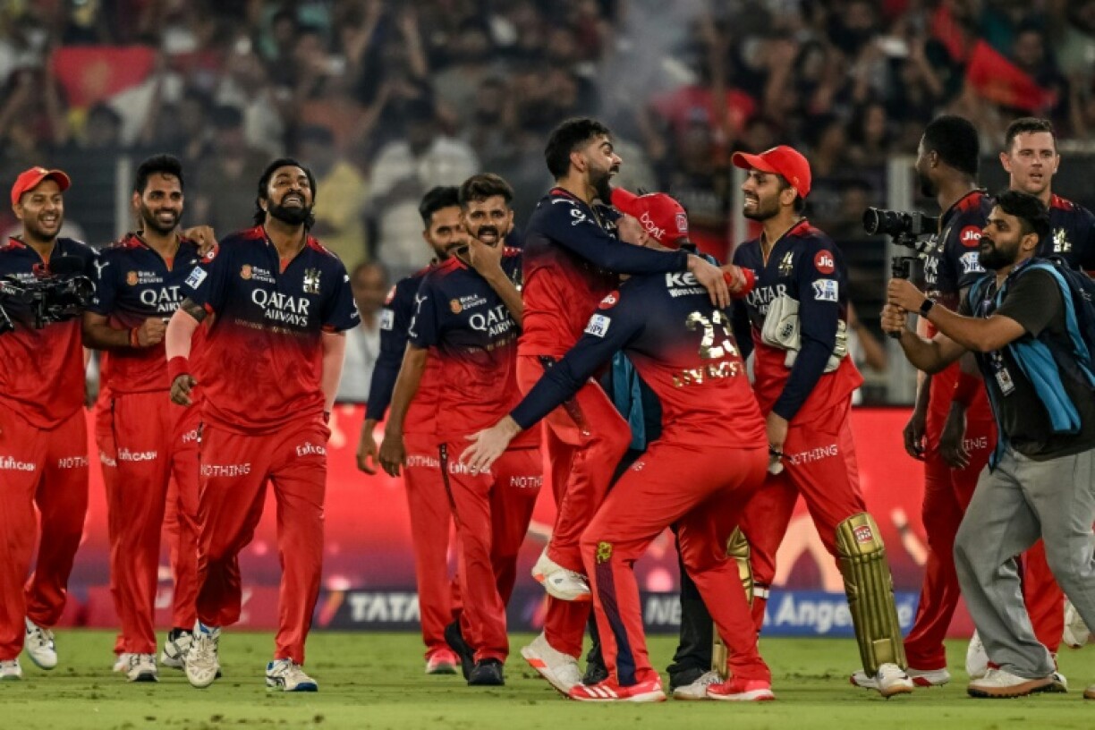 Virat Kohli (C) is mobbed by his teammates after Royal Challengers Bengaluru won their first ever Indian Premier League title