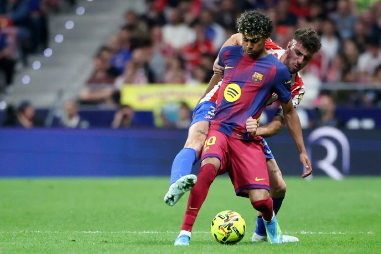 Lamine Yamal (G) du Barça aux prises avec le défenseur de l'Atlético Madrid Matteo Ruggeri lors de la victoire des Catalans 2-1, le 4 avril 2026 au stade Metropolitano de Madrid