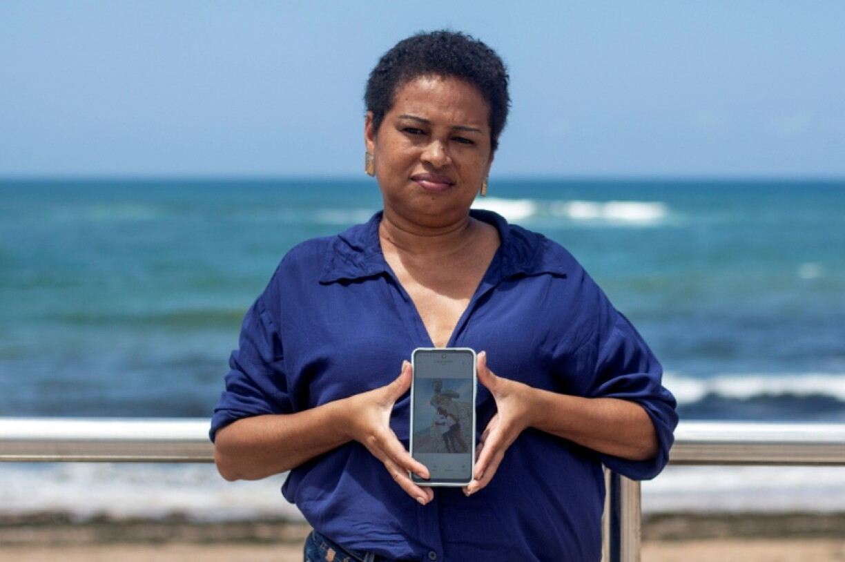 Vilma Alves de Oliveira holds the last photo she has with her son, who she claims was killed by police three years ago