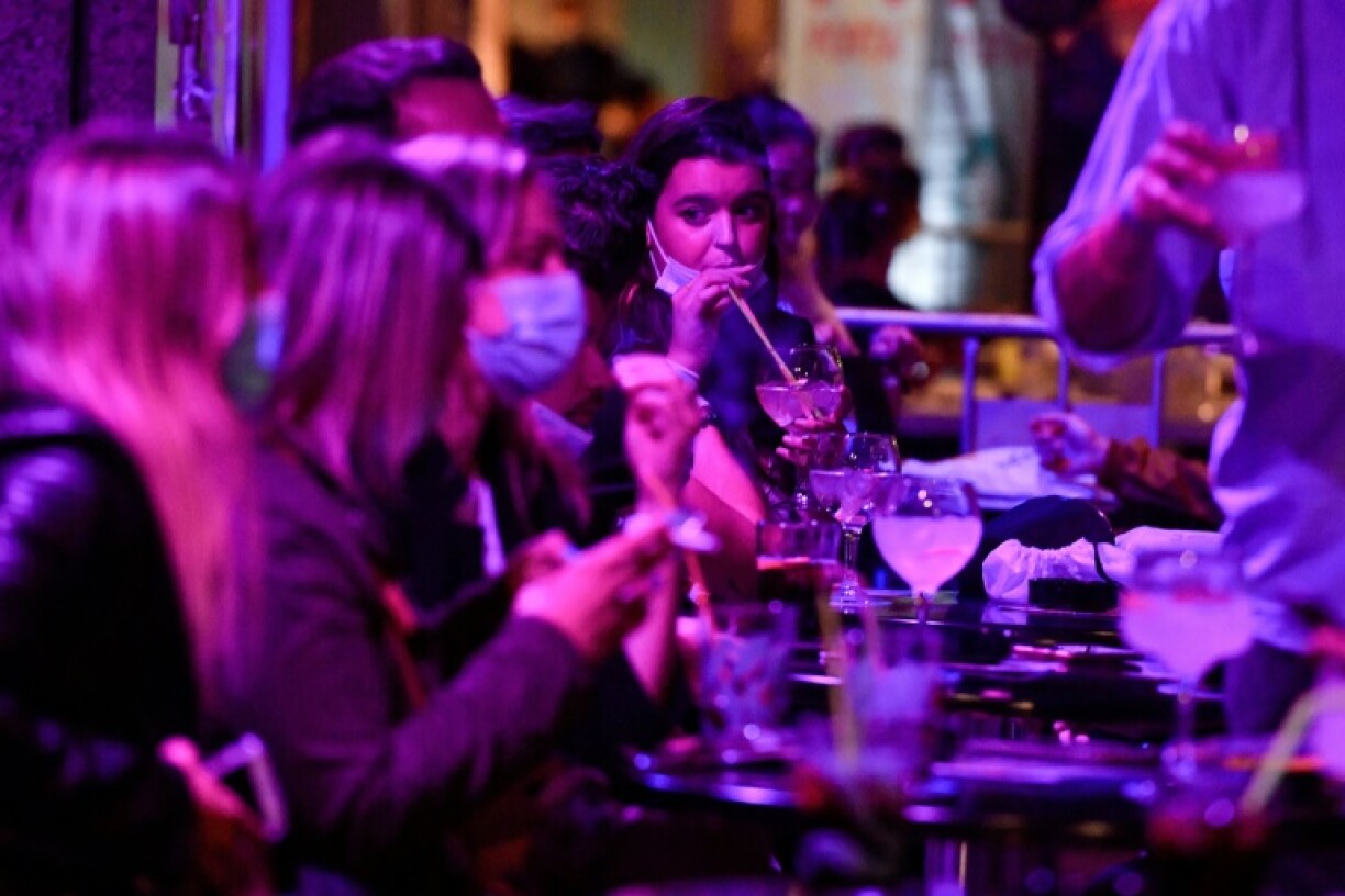 Des personnes à la terrasse d'un bar lors d'une étude clinique sur une possible réouverture des bars de nuit et discothèques, le 20 mai 2021 à Sitges, en Espagne