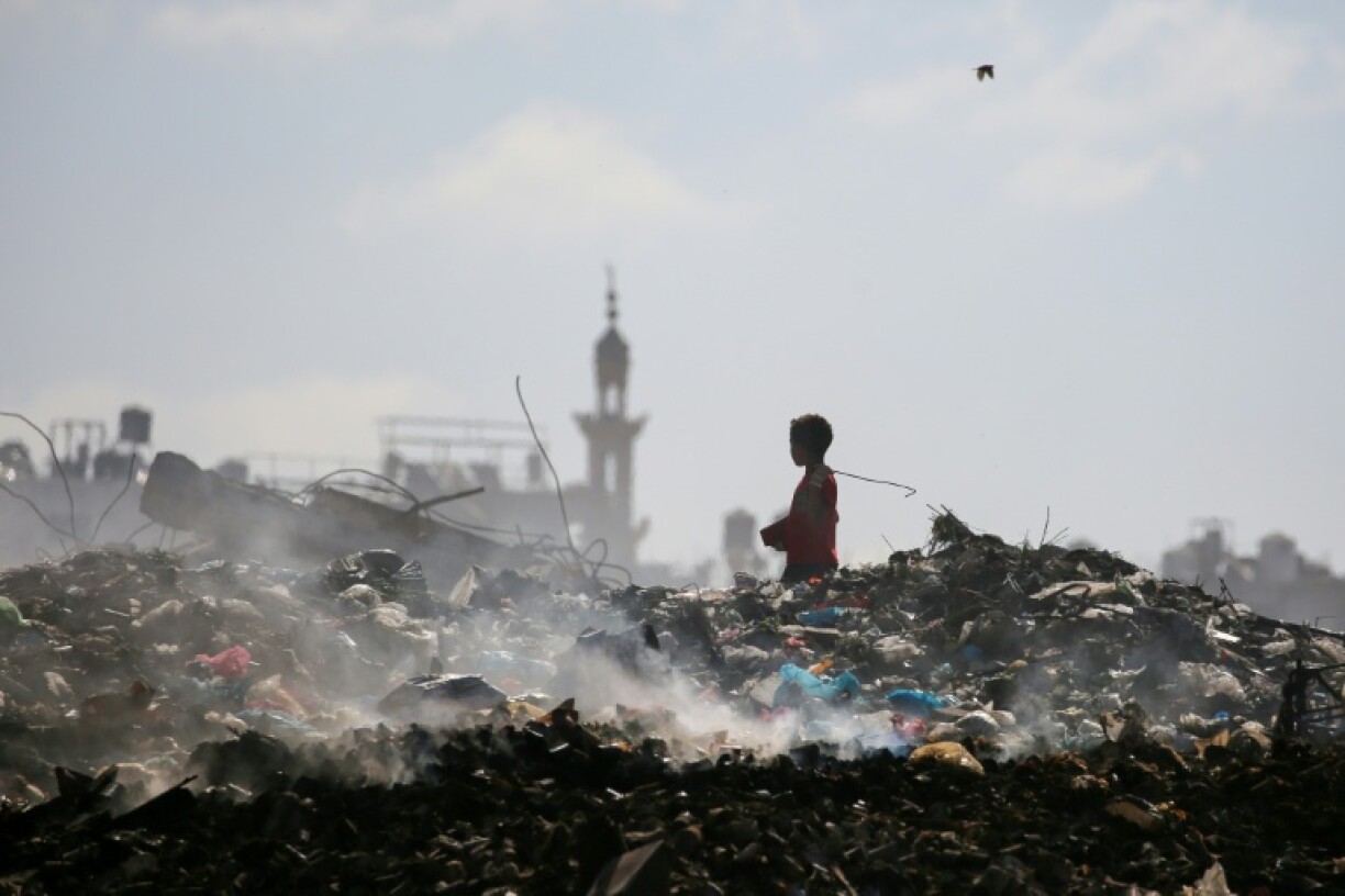 A Palestinian boy searches through a garbage waste dump in the central Gaza Strip, where 21 months of war have created a dire humanitarian crisis