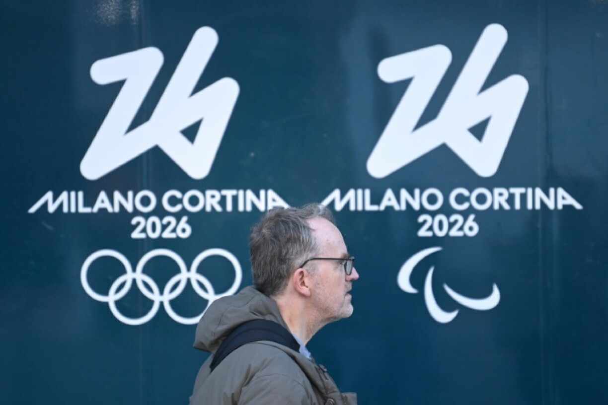 Une personne passe devant les logos des Jeux olympiques et paralympiques d'hiver de Milan Cortina, à Milan, le 5 février 2026