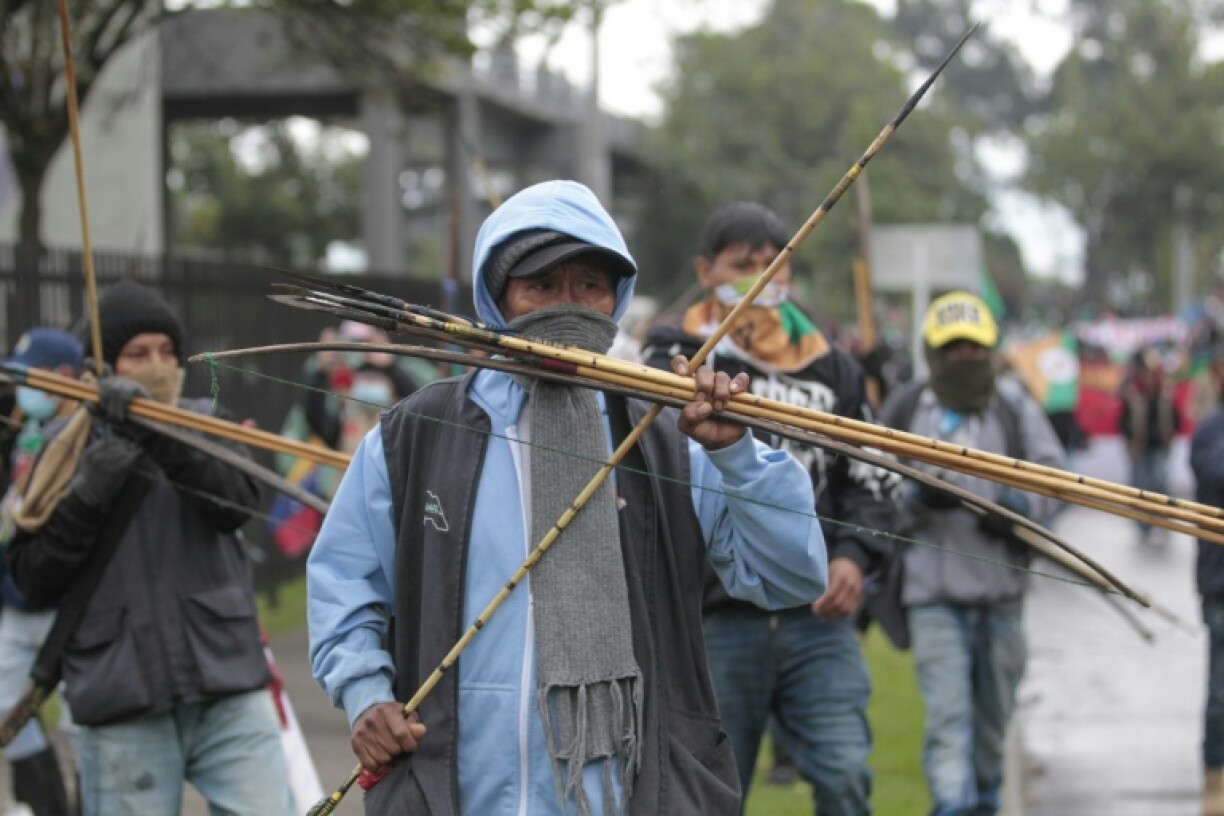 A protester holds a bow and arrow during a demonstration outside the US embassy in Bogota, Colombia
